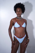 Model wearing Sandy Bikini Bottom Blue featuring a light blue design with red accents.